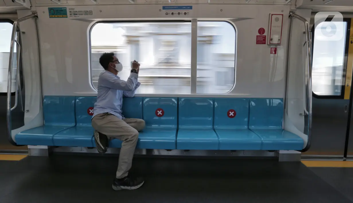 Seorang penumpang mengambil gambar dari dalam Moda Raya Terpadu (MRT) yang sepi saat Lebaran di Jakarta, Minggu (24/5/2020). Di tengah pandemi virus corona COVID-19, pengguna MRT terpantau sepi tak seperti libur Lebaran sebelumnya. (Liputan6.com/Johan Tallo)