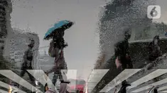 Pekerja melintas di pelican crossing di kawasan Perkantoran Sudirman, Jakarta, Rabu (26/4/2023). (Liputan6.com/Faizal Fanani)