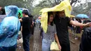 Penonton mengenakan jas hujan saat mengantre tiket konser Liam Gallagher di Ecovention Ancol, Jakarta Utara, Minggu (14/1). Selain penggemar dari kalangan umum, sejumlah selebritis dikabarkan akan meramaikan konser tersebut. (Liputan6.com/JohanTallo)
