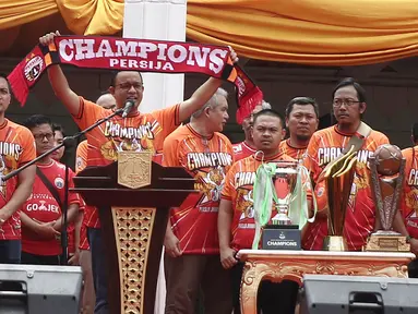 Gubernur DKI Jakarta Anies Baswedan membentangkan syal saat memberi sambutan dalam penyerahan piala Liga I di Balai Kota, Jakarta, Sabtu (15/12). Kemenangan Persija di Liga 1 jadi momen bersejarah bagi masyarakat DKI. (Liputan6.com/Herman Zakharia)