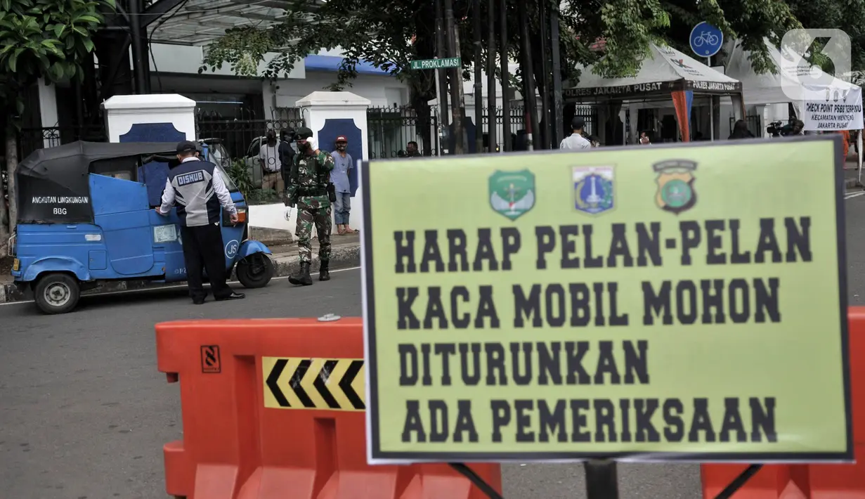 Petugas memeriksa jumlah penumpang salah satu taksi saat penindakan Pembatasan Sosial Berskala Besar (PSBB) di kawasan Menteng, Jakarta, Senin (13/4/2020). Aturan bagi pengendara saat PSBB berlangsung antara lain wajib mengenakan masker dan sarung tangan bagi pengendara motor. (merdeka.com/Iqbal S.