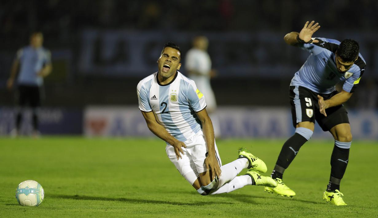 Pemain Argentina, Gabriel Mercado (kiri) menahan sakit berebut bola dengan pemain Uruguay, Luis Suarez pada laga kualifikasi Piala Dunia 2018 di Montevideo, Uruguay, (31/8/2017). Argentina bermain imbang 0-0. (AP/Natacha Pisarenko)