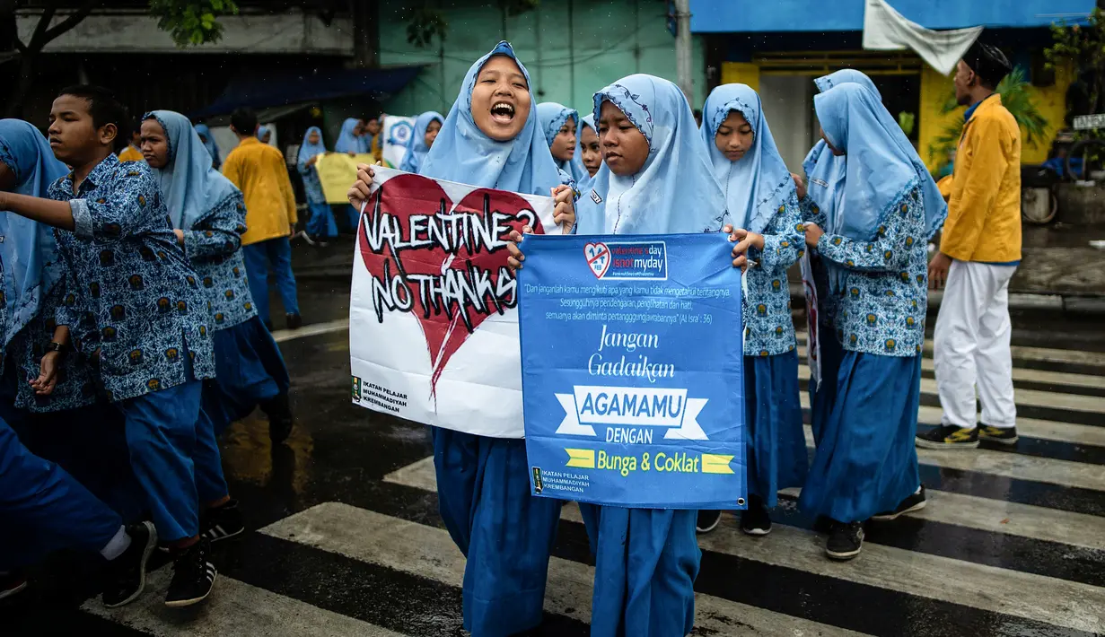Sejumlah pelajar membawa spanduk saat menggelar demonstrasi menolak perayaan Hari Valentine di Surabaya, Jawa Timur, Kamis (14/2). Penolakan terjadi karena Valentine dinilai mempromosikan pergaulan bebas. (Juni Kriswanto/AFP)