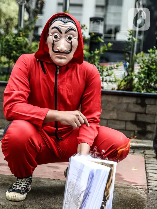 Seorang mahasiswa dari Mahasiswa Independen secara simbolis membakar salinan naskah UU Cipta Kerja di depan Gedung MK, Jakarta, Selasa (27/10/2020). Mahasiswa menyatakan aksi tersebut bentuk ketidakpercayaan kepada MK bila proses uji materi UU Cipta Kerja dilakukan. (Liputan6.com/Faizal Fanani)
