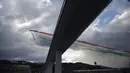 Tim aerobatik Angkatan Udara Italia, Frecce Tricolori (Panah Tiga Warna), terbang di atas Jembatan Saint George Genoa baru di Genoa, Italia, Senin (3/8/2020). Jembatan tersebut dibangun untuk menggantikan viaduk yang ambruk dua tahun lalu dan menewaskan 43 orang. (Xinhua/Stringer)