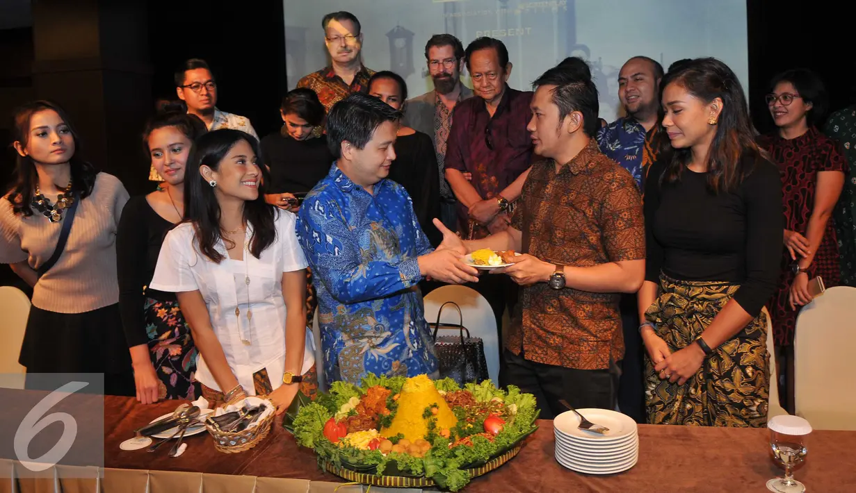 Sutradara Hanung Bramantyo menerima potongan tumpeng saat Syukuran Film Kartini di XXI Jakarta Theater, Jakarta, Kamis (14/7). Rencananya film Kartini akan tayang di bioskop pada April 2017. (Liputan6.com/Gempur M Surya)