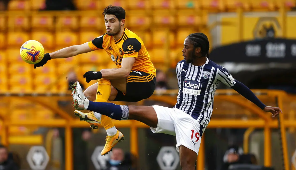 Pemain Wolverhampton Wanderers, Pedro Neto, berebut bola dengan pemain West Bromwich Albion, Romaine Sawyers, pada laga Liga Inggris di Stadion Molineux, Sabtu (16/1/2021). Wolves takluk dengan skor 2-3. (Adrian Dennis/Pool via AP)