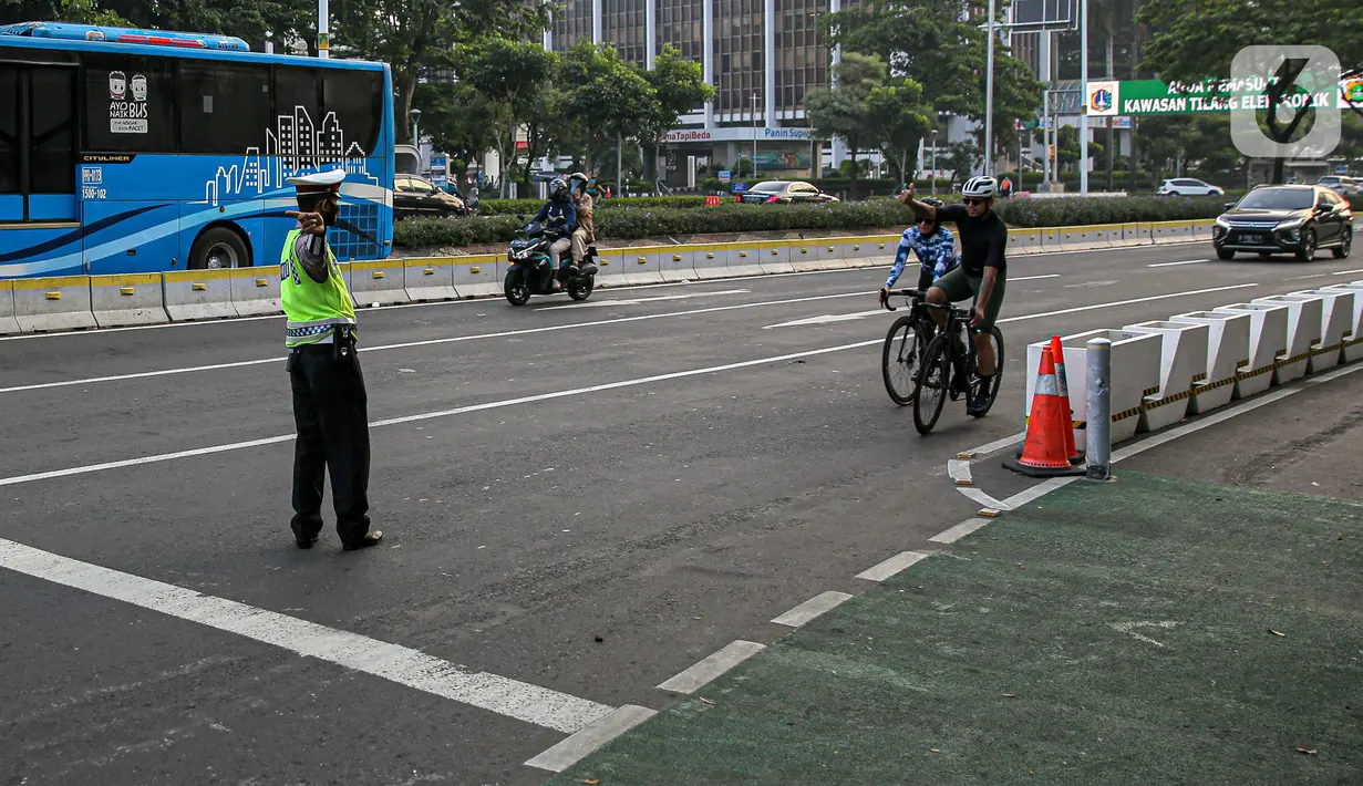 Polisi menghalau pesepeda yang berada di luar jalur di kawasan Sudirman-Thamrin, Jakarta Pusat, Rabu (2/6/2021). Wakil Gubernur DKI Jakarta Ahmad Riza Patria mengatakan, sepeda road bike diperbolehkan untuk melintas di Jalan Sudirman-Thamrin pada hari kerja Senin-Jumat. (Liputan6.com/Faizal Fanani)
