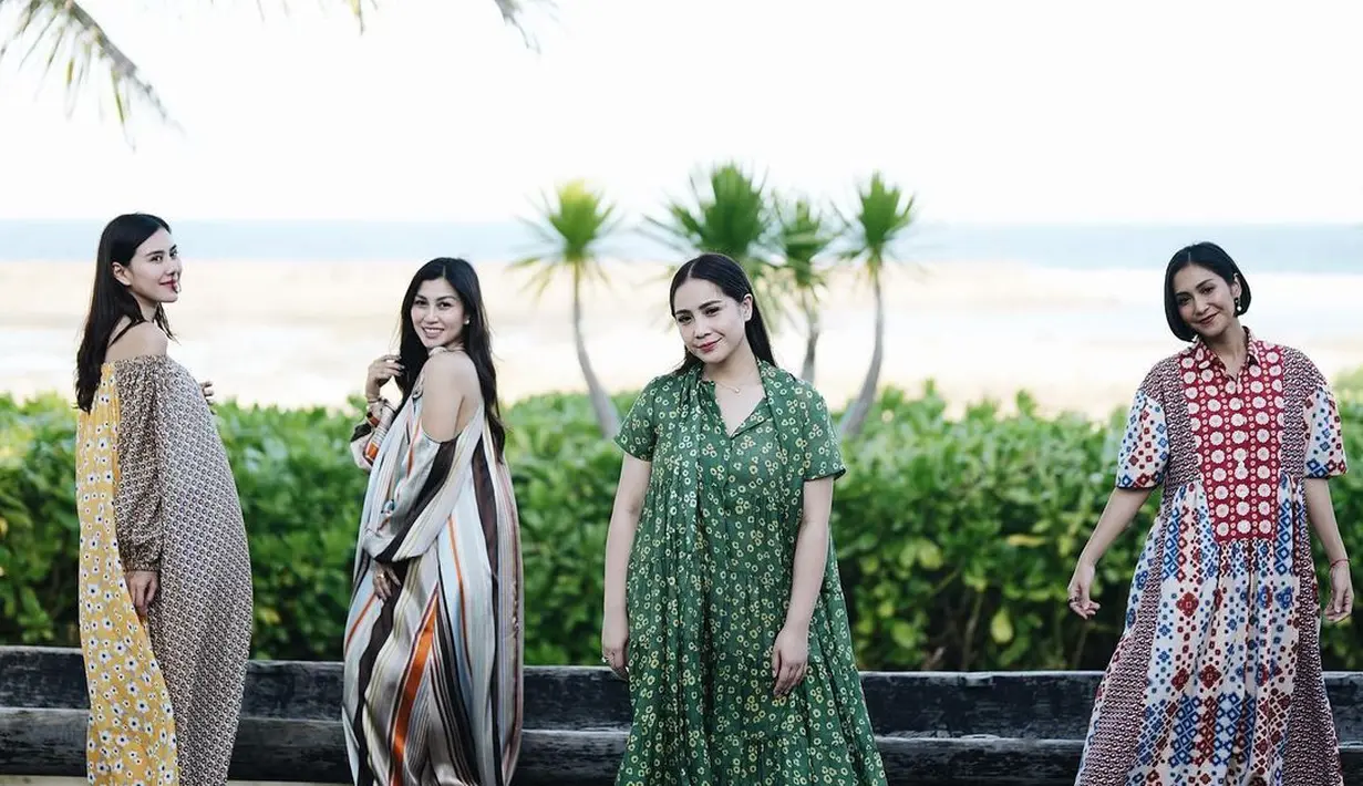 Nagita Slavina mengenakan long dress berwarna hijau. Dress ini memiliki motif minimalis bunga-bunga matahari berwarna kuning yang cantik. Foto: Instagram.