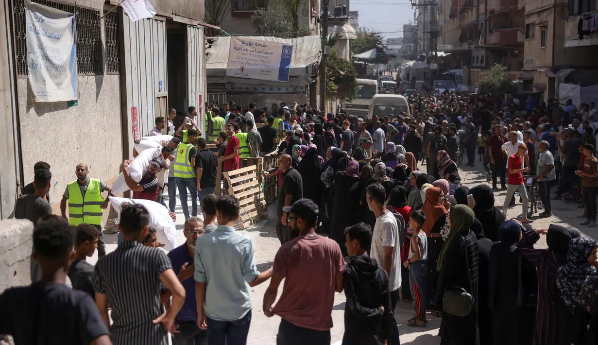 Warga Palestina beramai-ramai mendatangi pusat distribusi bantuan kemanusiaan yang didirikan oleh Save Youth Future Society (SYFS), yang bekerja sama dengan Program Pangan Dunia PBB (WFP), di Kota Gaza pada 26 Juni 2025. (BASHAR TALEB/AFP)