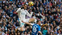 Pemain Real Madrid, Gareth Bale melompat untuk merebut bola dari pemain Deportivo La Coruna, Luisinho dalam lanjutan La Liga Spanyol di Santiago Bernabue, Senin (22/1). Real Madrid pesta kemenangan 7-1 atas Deportivo La Coruna. (AP/Francisco Seco)