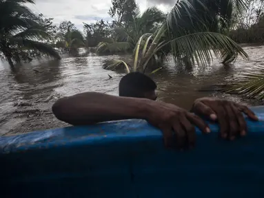 Seorang pria menarik kano di daerah banjir yang disebabkan oleh Sungai Wawa Boom setelah melintas Badai Iota di Bilwi, Puerto Cabezas, Nikaragua (18/11/2020). Badai Iota telah menewaskan sedikitnya sembilan orang saat menghancurkan rumah, menumbangkan pohon dan menggenangi air. (AFP/Inti Ocon)