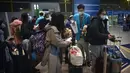 Pekerja membantu pelancong mengisi status kesehatan elektronik COVID-19 mereka di area kedatangan internasional di Bandara Internasional Beijing, China (9/1/2023). Pelancong internasional pertama tiba di China tanpa karantina wajib yang telah diberlakukan pada awal penerbangan. Pandemi tiga tahun lalu setelah pembatasan dicabut mulai hari Minggu. (AP/Mark Schiefelbein)