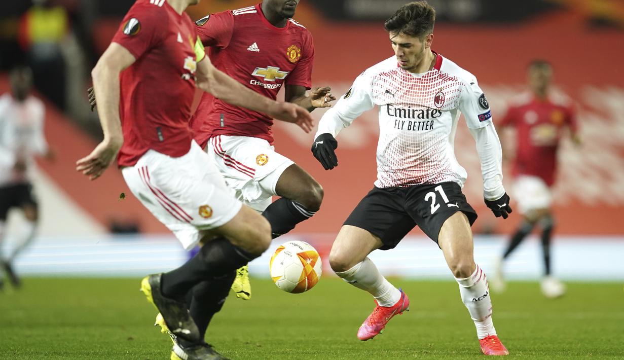 Gelandang AC Milan, Brahim Diaz berusaha melewati dua pemain Manchester United pada pertandingan leg pertama babak 16 besar Liga Europa di Old Trafford, Inggris, Jumat (12/3/2021). Hasil ini penting bagi AC Milan dalam format duel dua leg. (AP Photo/Dave Thompson)