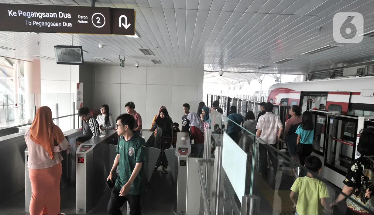 Kerumunan warga saat menggunakan jasa kereta LRT Jakarta di Stasiun Velodrome, Jakarta, Minggu (1/12/2019). Kereta LRT Jakarta rute Velodrome-Kelapa Gading beroperasi secara komersial mulai hari ini (1/12) dengan tarif Rp5.000 flat untuk sekali perjalanan. (merdeka.com/Iqbal S. Nugroho)