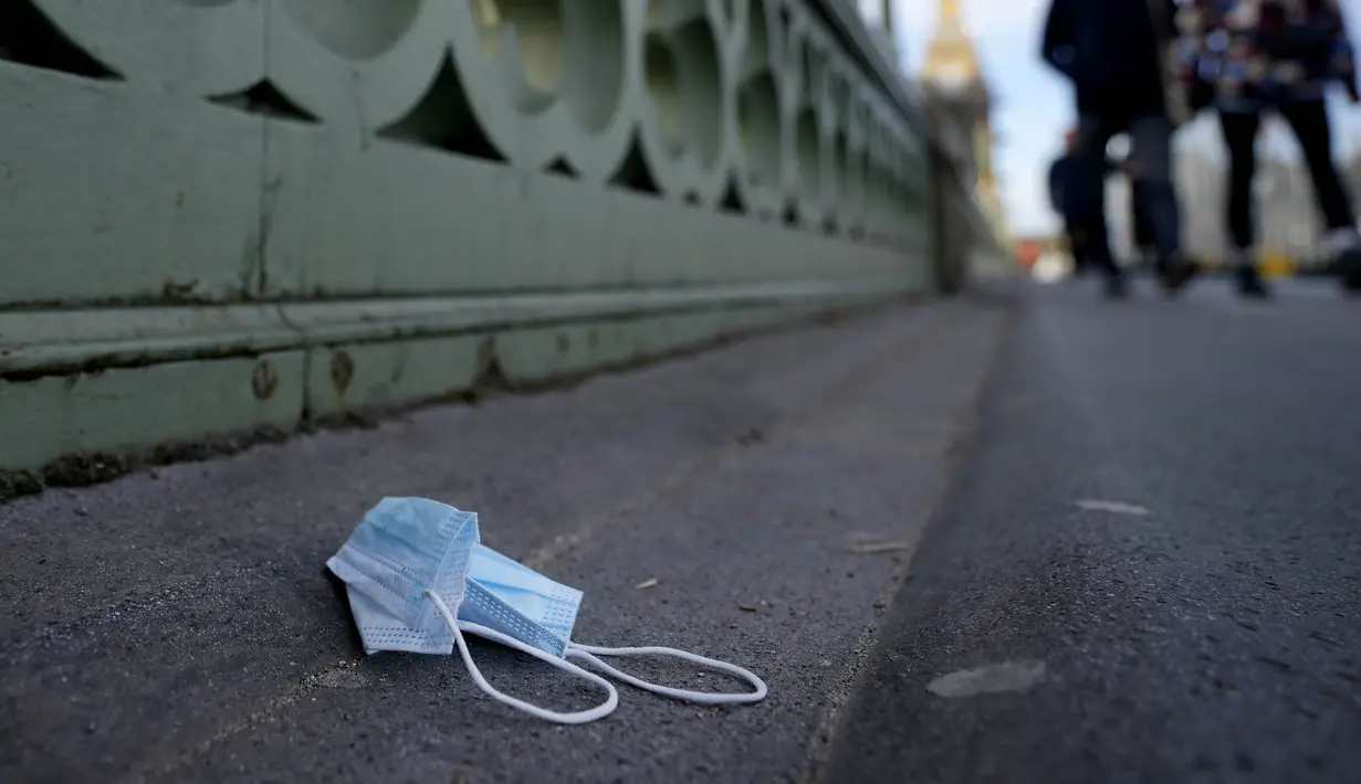 Masker wajah bekas tergeletak di Westminster Bridge, London, Kamis (9/12/2021). Perdana Menteri Inggris Boris Johnson kembali mendesak orang untuk bekerja dari rumah dan kewajiban menunjukkan sertifikat vaksin untuk memasuki klub malam dan tempat dengan kerumunan besar. (AP Photo/Frank Augstein)