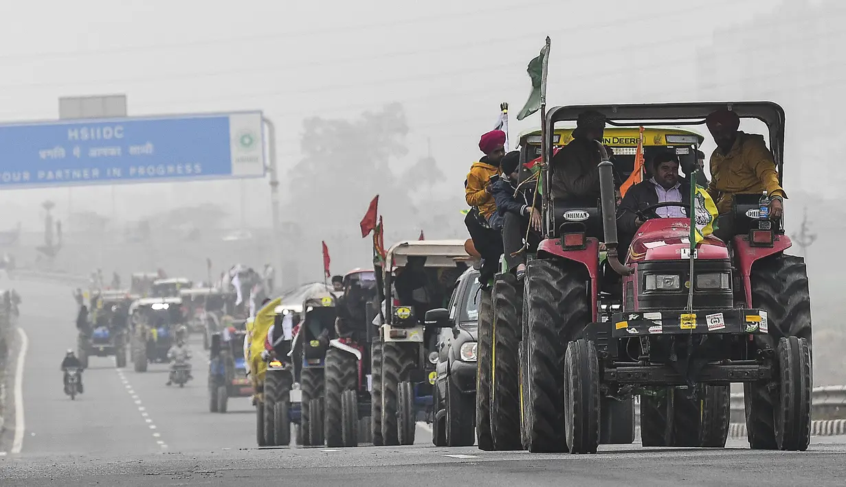 Para petani mrmbawa traktor berpartisipasi dalam unjuk rasa di Jalan Tol Kundli – Manesar – Palwal (KMP) di Kundli di negara bagian Haryana (7/1/2021). Serikat petani menuntut pencabutan tiga undang-undang pertanian baru dan pengadaan tanaman dengan Harga Dukungan Minimum (MSP). (AFP/Prakash Singh)