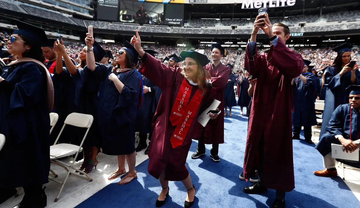 Peserta wisuda menari saat menyaksikan Jon Bon Jovi pada pesta kelulusan Universitas Fairleigh Dickinson di New Jersey, AS, Selasa (16/5). Jon Bon Jovi memberikan kejutan kepada undangan dan peserta wisuda di universitas tersebut. (AP Photo/Julio Cortez)
