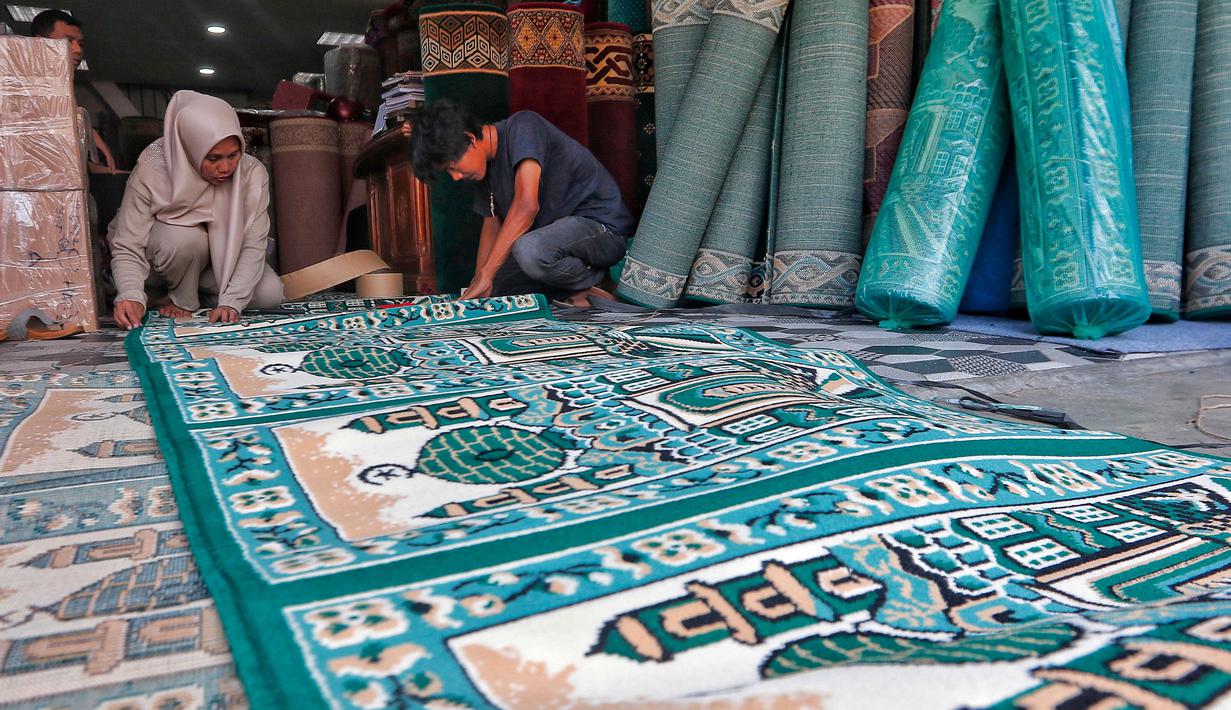 Pekerja mengecek karpet masjid pesanan pembeli di sebuah toko di kawasan Tanah Abang, Jakarta, Kamis (16/3/2023). (Liputan6.com/Angga Yuniar)