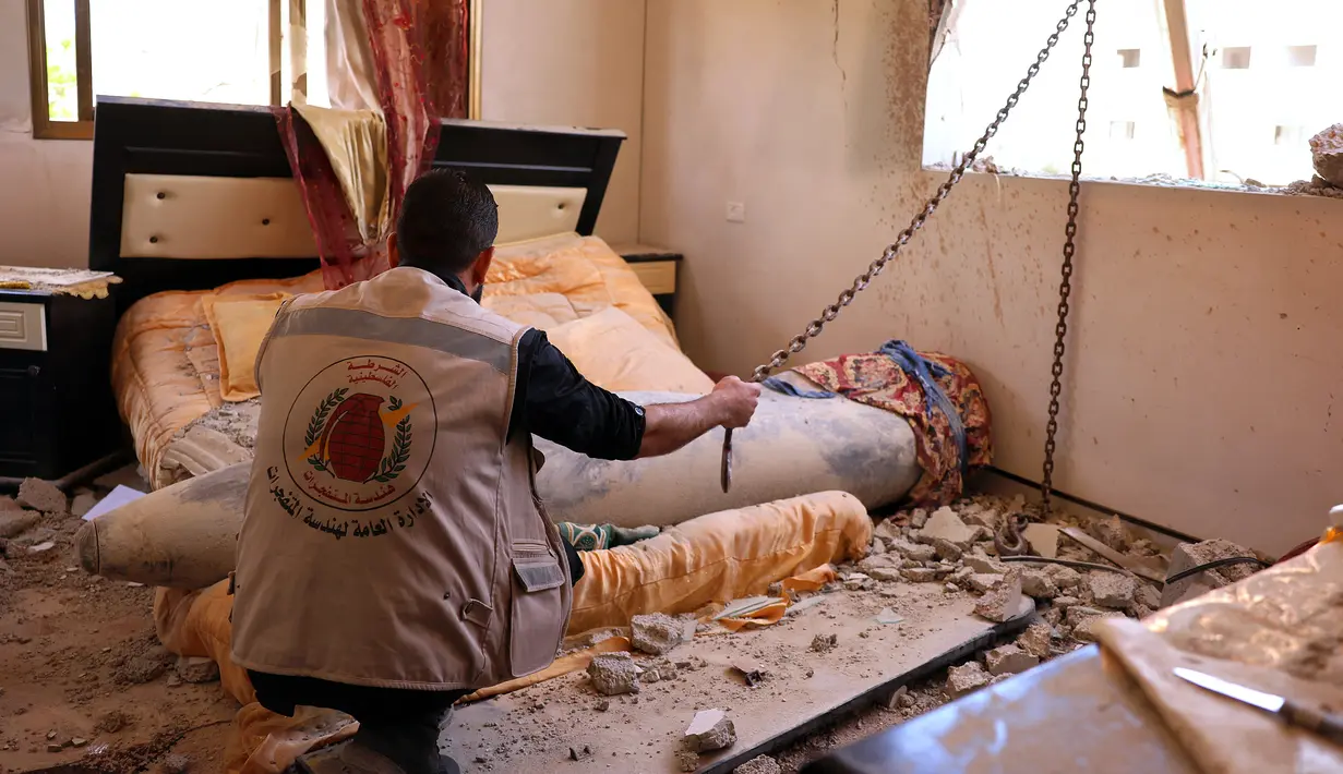 Pakar peledak Hamas saat sedang memeriksa rudal Israel yang tidak meledak setelah menghantam di sebuah rumah di Khan Yunis, Jalur Gaza selatan (20/5/2021). (AFP/Said Khatib)