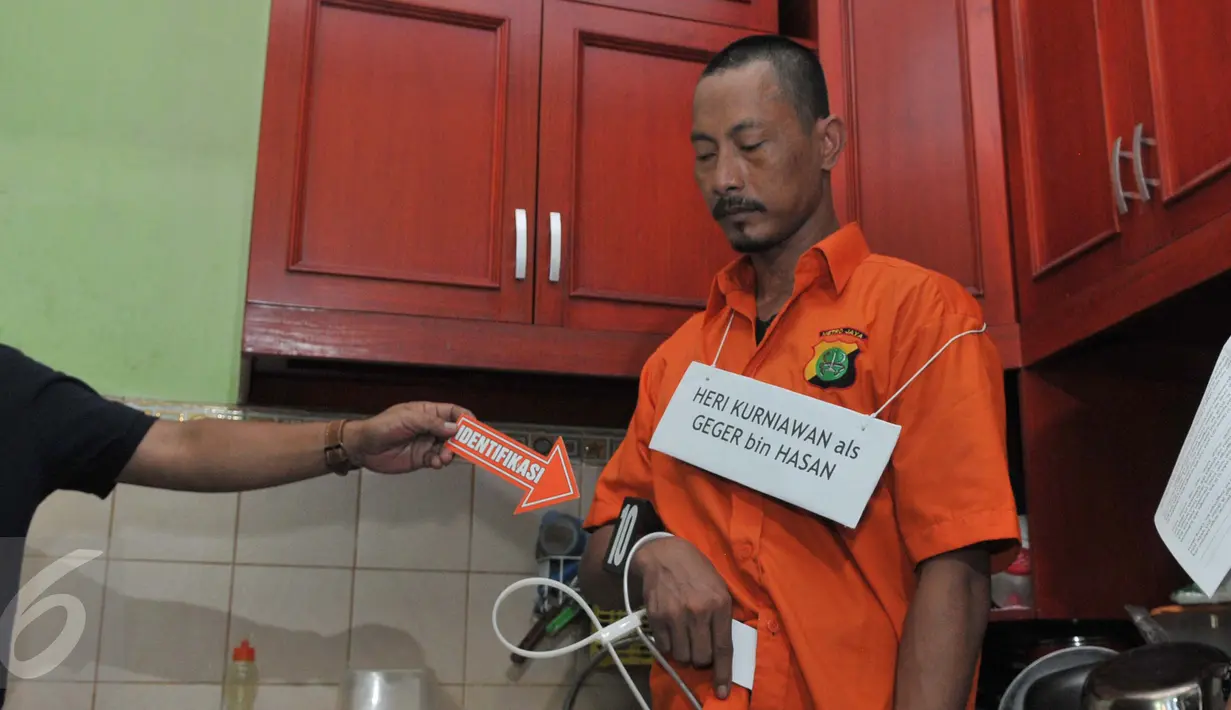 Tersangka pembunuhan ibu dan anak, Dayu Pri Ambarita dan Yuel Imanuel mengikuti rekonstruksi pembunuhan di Perumahan Aneka Elok, Cakung, Jakarta, Selasa (27/10). Mengenakan baju tahanan, Heri datang dengan pengawalan ketat. (Liputan6.com/Andrian M Tunay)