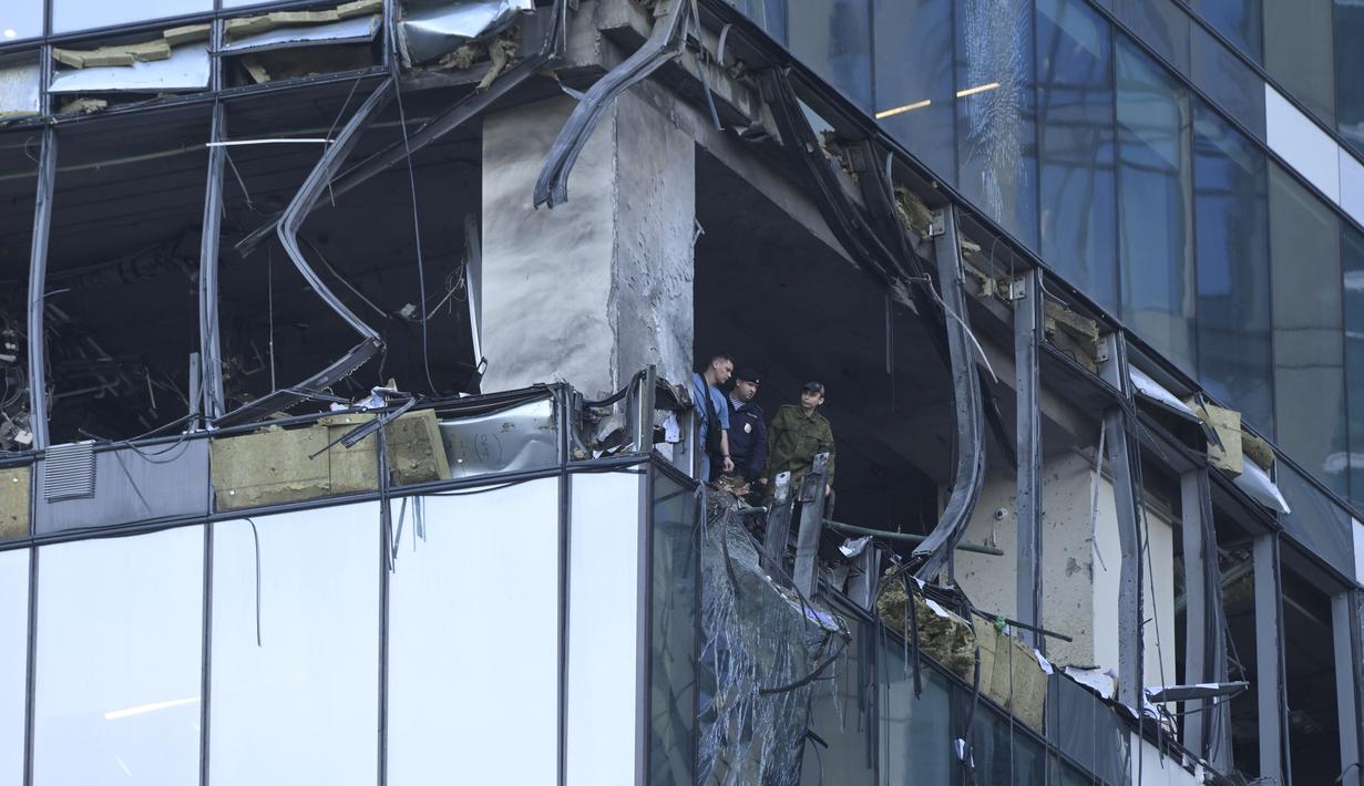 Penyelidik memeriksa gedung pencakar langit yang rusak di kawasan bisnis "Kota Moskow" setelah serangan drone yang dilaporkan di Moskow, Rusia, Minggu dini hari (30/7/2023). (AP Photo)