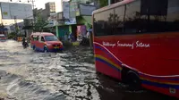 Sejumlah kendaraan melintasi jalan yang tergenang banjir rob di ruas jalur pantura Semarang-Demak ,Jawa Tengah, Minggu (12 /06/2016). Meski banjir yang cukup tinggi hanya kendaraan besar truk atau bus yang bisa melintas. (Gholib)