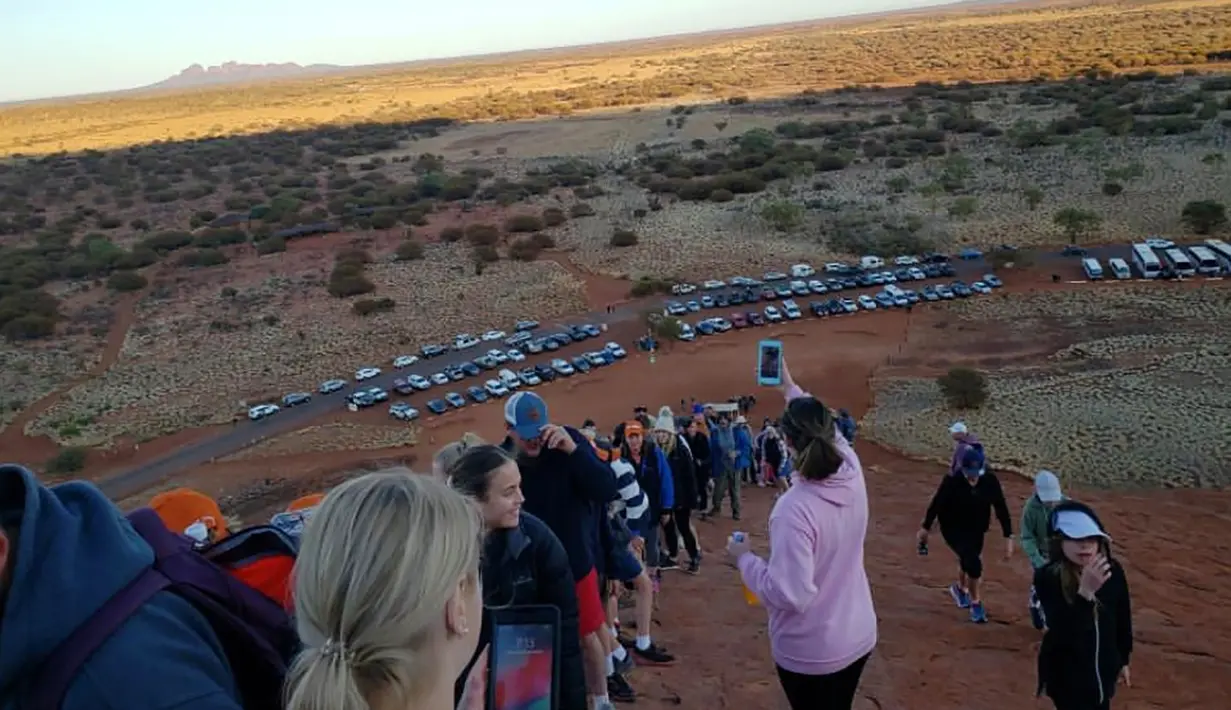 Selebaran yang diterima pada 10 Oktober 2019 memperlihatkan para wisatawan mendaki Uluru di Utara Australia.  Para pengunjung yang mengetahui rencana penutupan situs gunung batu ikonik tersebut langsung menyerbu Uluru untuk kemah dan mendaki sebelum larangan resmi diterapkan. (HO/ @koki_mel_aus/AFP)