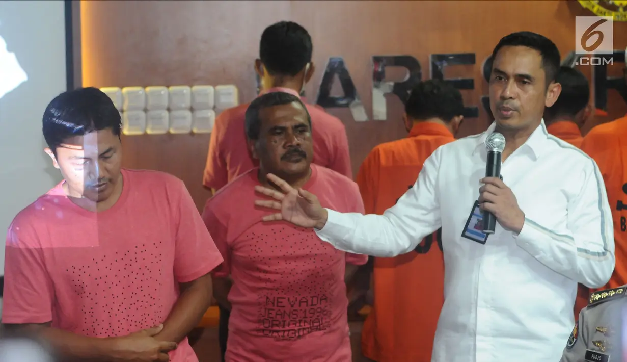 Kasubdit I Dittipid Siber Bareskrim Polri Kombes Pol Irwan Anwar menunjukkan foto tersangka kejahatan siber saat rilis di Jakarta, Rabu (21/2). Dittipid Siber Bareskrim Polri menahan 18 tersangka penyebaran hoax. (Liputan6.com/Helmi Fithriansyah)