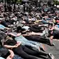 Anggota komunitas LGBTQ bersama pengunjuk rasa Black Lives Matter melakukan aksi tiarap di jalan dengan tangan seolah terikat di West Hollywood, California, Rabu (3/6/2020). Aksi menyimbolkan momen terakhir George Floyd saat lehernya ditindih lutut polisi Minneapolis pada 25 Mei. (AP/Richard Vogel)