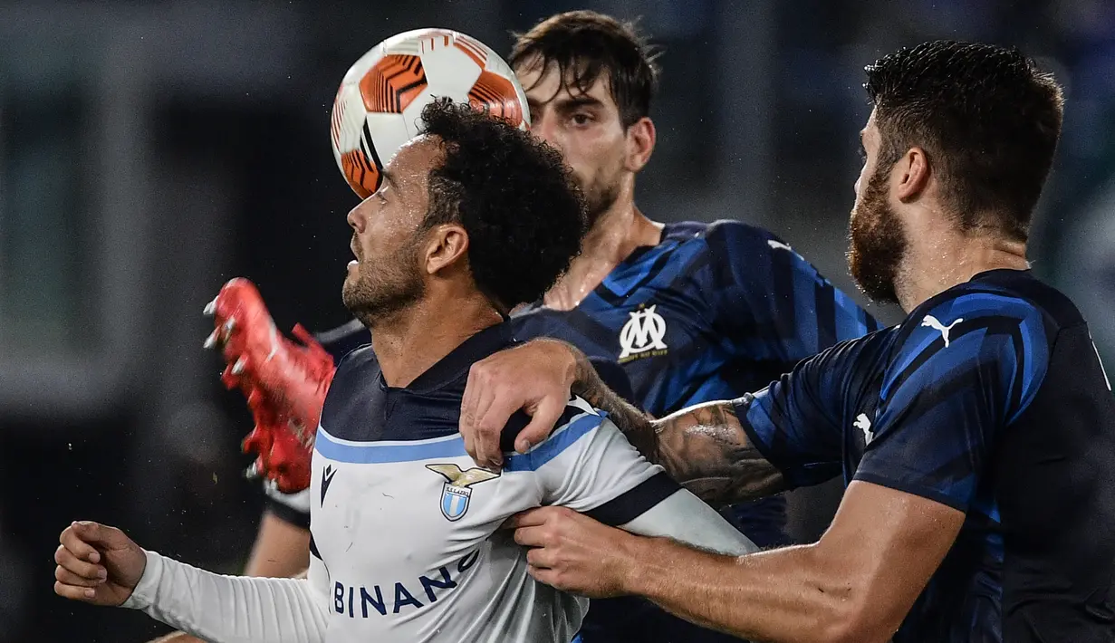 Bek Olympique Marseille, Duje Caleta Car (kanan) menahan gelandang Lazio Felipe Anderson pada matchday kedua Grup E Liga Europa 2021 di Stadion Olimpico Roma, Kamis (21/10/2021) malam WIB. Lazio hanya mampu bermain imbang 0-0 kala menjamu Marseille. (Filippo MONTEFORTE / AFP)