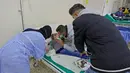 Seorang pria menghibur seorang pasien anak yang terinfeksi wabah kolera Vibrio dan menerima perawatan di aula masjid yang diubah menjadi rumah sakit lapangan di Kota Bebnine, Distrik Akkar, Lebanon Utara, Rabu (26/10/2022). Kolera dapat menjangkit anak-anak dan orang dewasa, dan bisa berakibat fatal jika tidak diobati. (AFP/Ibrahim Chalhoub)