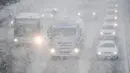 Sejumlah kendaraan melintas saat hujan salju turun di Munich, Jerman selatan, (18/4). Hujan salju yang melanda kawasan ini tidak menyurutkan warga untuk tetap beraktivitas. (AFP PHOTO / dpa / Tobias Hase / Jerman OUT)
