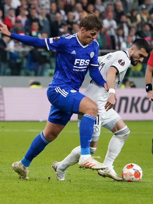 Bek Leicester City Jannik Vestergaard (kiri) berebut bola dengan gelandang Legia Warszawa Mahir Emreli pada matchday kedua Grup C Liga Europa 2021/2022 di Polish Army stadium, Kamis (31/9/2021). Leicester City kalah 0-1 di markas Legia Warszawa. (JANEK SKARZYNSKI / AFP)
