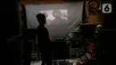 Adul (29) mengecek video di sebuah layar di gudang rumahnya di Jakarta, Rabu (28/4/2021). Sebelum masa pandemi, industri layar tancap memang perlahan mulai redup. (Liputan6.com/Johan Tallo)