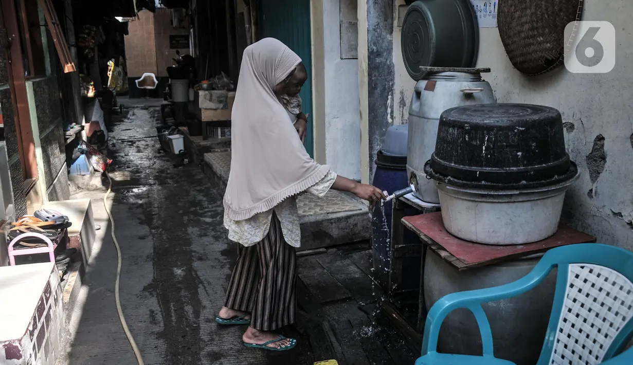 Warga menggunakan air tampungan di Kampung Baru Kubur, Penjaringan, Jakarta Utara, Selasa (11/1/2022). Warga mengaku krisis air bersih terjadi pada pagi dan sore hari, baik pengguna air ledeng atau tanah maupun Palyja. (merdeka.com/Iqbal S. Nugroho)