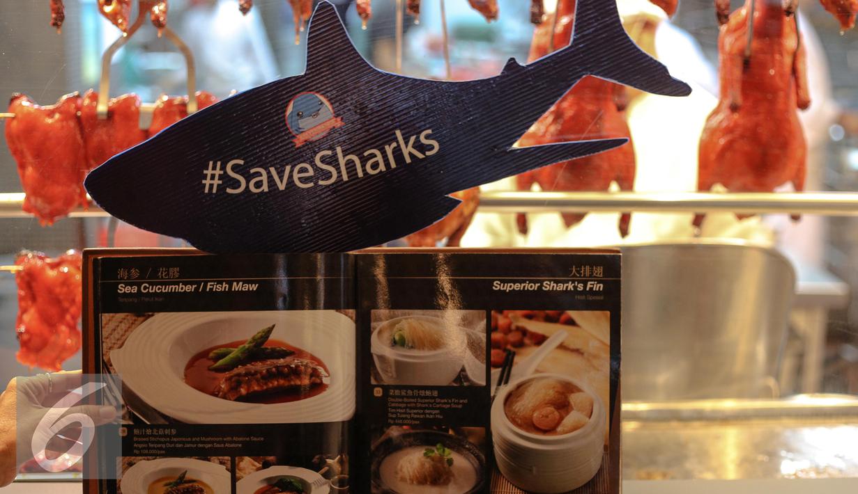 Terlihat menu makanan dan replika hiu bertuliskan SaveSharks di salah satu rumah makan, Jakarta, Minggu (12/7/2015). Aksi tersebut sebagai upaya menyelamatkan hiu dari kepunahan. (Liputan6.com/Faizal Fanani)