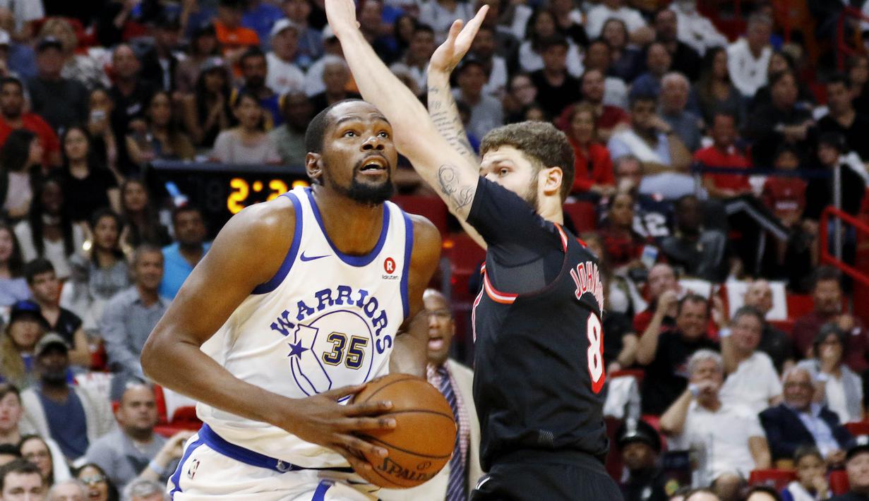 Pebasket Golden State Warriors, Kevin Durant, berusaha melewati pebasket Miami Heat, Tyler Johnson, pada laga NBA di American Airlines Arena, Miami, Senin (4/12/2017). Warriors menang 123-95 atas Heat. (AP/Joe Skipper)