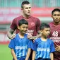 Aaron Evans dan Player Escort Kids Allianz pada lanjutan penyisihan Grup H Piala AFC 2019 antara PSM Makassar Vs Home United, Selasa (30/4/2019) di Stadion Pakansari, Kab. Bogor. (Bola.com/Vitalis Yogi Trisna)