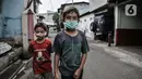 Anak-anak mengenakan masker saat bermain di wilayah Zona Merah RW 03 Kelurahan Kebon Manggis, Jakarta, Selasa (14/7/2020). Terus meningkatnya kasus positif Covid-19 menyebabkan jumlah RW di DKI yang masuk dalam Zona Merah bertambah menjadi 30 lokasi. (merdeka.com/Iqbal Nugroho)