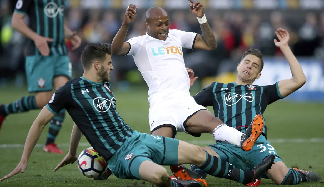 Pemain Swansea City, Andre Ayew (tengah) saat berebut bola dengan dua pemain Southampton pada lanjutan Premier League di Liberty Stadium, Swansea, (8/5/2018). Swasea City kalah dari Soton 0-1. (Nick Potts/PA via AP)