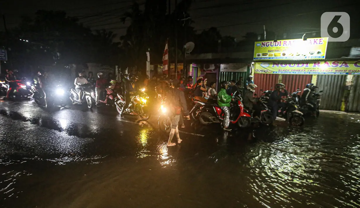Sejumlah pengendara sepeda motor terjebak banjir di Jalan Ciracas Raya, Jakarta, Jumat (12/8/2022). Hujan lebat yang terjadi sore tadi membuat Jalan Ciracas Raya tergenang air dan kendaraan terjebak banjir. (Liputan6.com/Faizal Fanani)