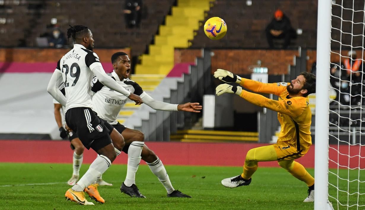 Kiper Liverpool, Alisson Becker melakukan penyelamatan dalam laga lanjutan Liga Inggris 2020/21 pekan ke-12 melawan Fulham di Craven Cottage, Minggu (13/12/2020). Liverpool bermain imbang 1-1 dengan Fulham. (AFP/Mike Hewitt/Pool)
