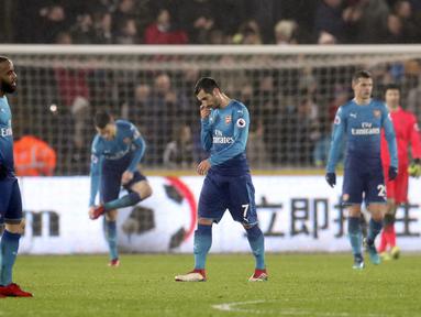 Pemain anyar Arsenal, Henrikh Mkhitaryan (tengah) terlihat kecewa saat timnya kalah dari Swansea City pada lanjutan Premier League di Liberty Stadium, Swansea, Wales, (30/1/2018). Arsenal kalah 1-3. (Nick Potts/PA via AP)