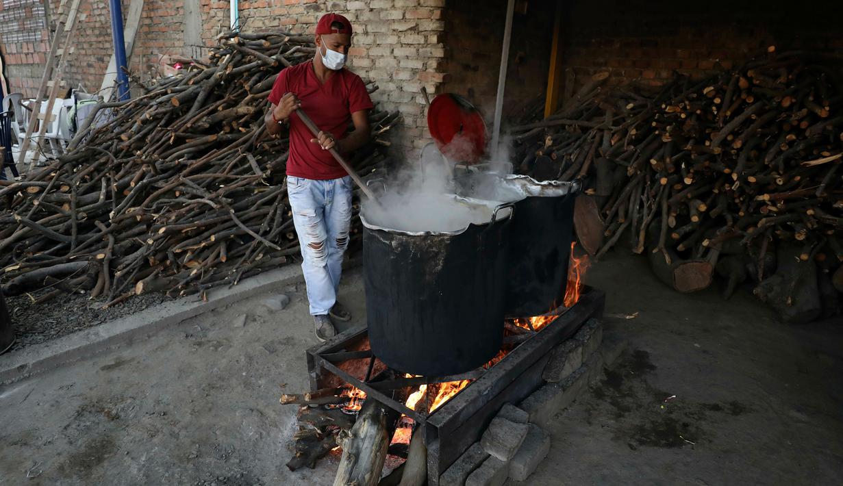 Relawan memasak kacang-kacangan untuk pengungsi Venezuela di tempat penampungan Divina Providencia, La Parada, Cucuta, Kolombia, Senin (18/2). Tempat penampungan ini melayani sekitar 4.500 makan siang per hari. (AP Photo/Fernando Vergara)