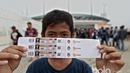 Seorang suporter cilik menunjukan tiket yang dibelinya pada loket pembelian tiket di Stadion Pakansari, Bogor, Sabtu (11/3/2017). (Bola.com/Nicklas Hanoatubun)