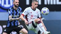 Gelandang Inter Milan, Marcelo Brozovic berduel dengan pemain Cagliari saat kedua tim bertemu di ajang Liga Italia 2020/2021, Minggu (11/04/2021). (Alberto PIZZOLI / AFP)