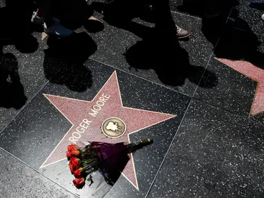 Sebuah buket bunga diletakkan di atas bintang Walk of Fame milik aktor Inggris, Roger Moore, di Hollywood, Los Angeles, Selasa (23/5). Aktor yang namanya dikenal karena memerankan James Bond itu meninggal dunia pada usia 89 tahun. (AP Photo/Jae C. Hong)