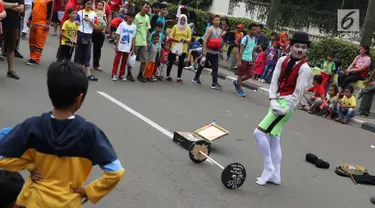 Seniman pantomim tampil menghibur pengunjung car free day di Jakarta, Minggu (1/7). Aksi tersebut dilakukan guna mengumpulkan biaya yang akan digunakan untuk menikah. (Liputan6.com/Immanuel Antonius)