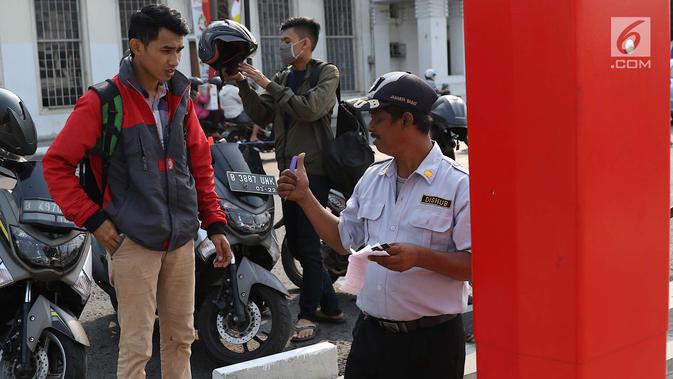Petugas berjaga di depan mesin parkir meter di kawasan Kota Tua, Jakarta, Rabu (18/7). Sebanyak 13 Terminal Parkir Elektronik (TPE) dipasang di kawasan tersebut guna mengantisipasi membludaknya kendaraan yang parkir. (Liputan6.com/Immanuel Antonius)